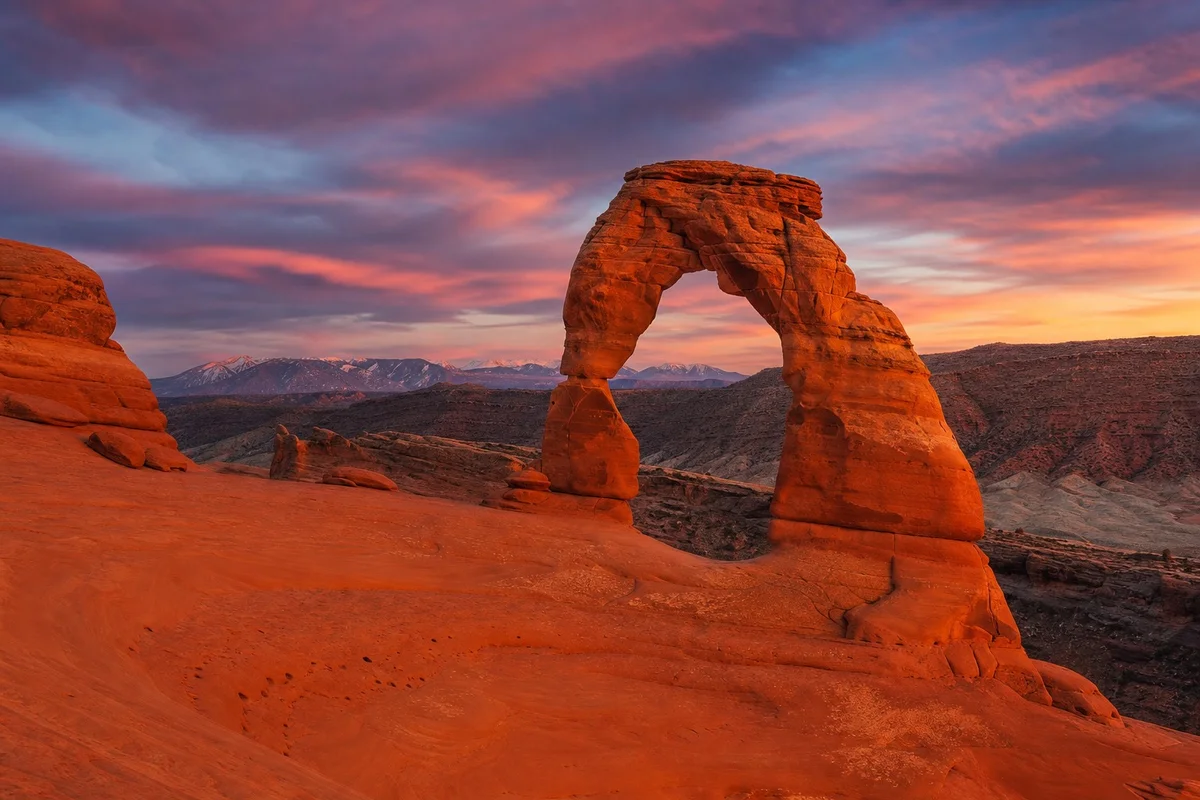 La célèbre Delicate Arch de grès rouge dans Arches National Park sous un ciel étoilé au coucher du soleil, Utah