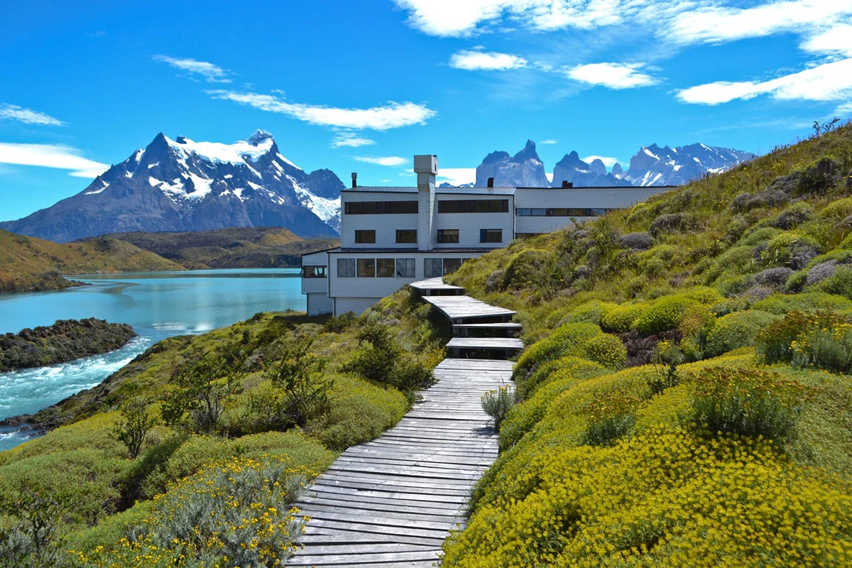 Lodge Explora Patagonia au bord du lac Pehoé avec vue sur les Torres del Paine sous un ciel bleu vif au Chili