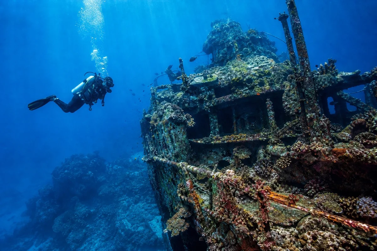 Plongeur explorant une épave de navire de guerre dans l'Iron Bottom Sound aux îles Salomon
